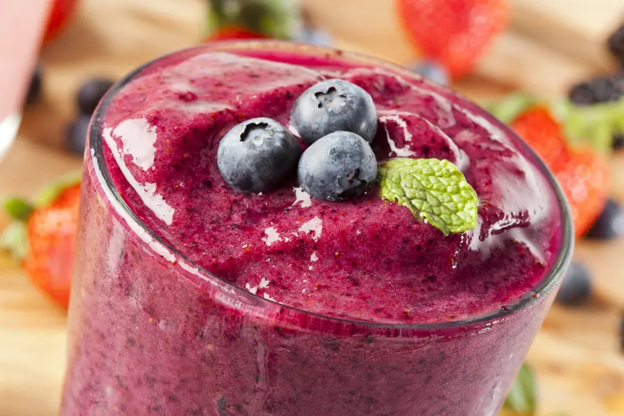 Close-up of a thick blueberry smoothie topped with fresh blueberries
