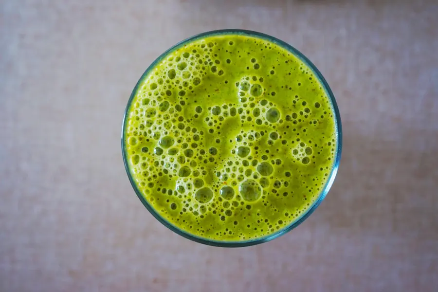 Overhead view of a bright green smoothie in a glass