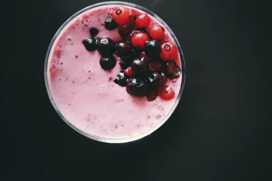Overhead view of a creamy pink berry dessert topped with blackberries and redcurrants